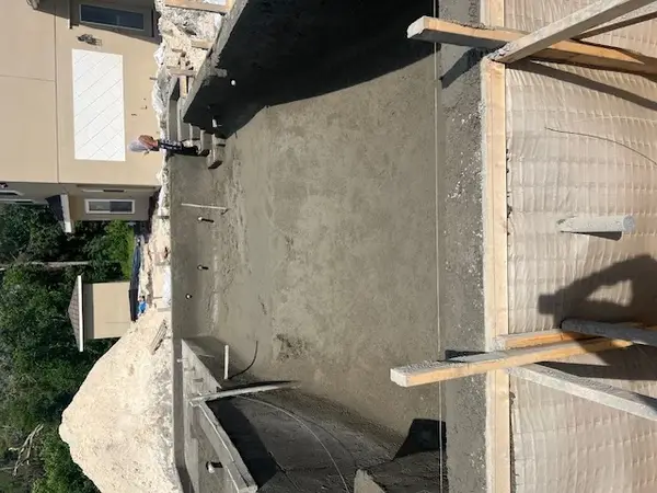 Top-down construction view of the main concrete pool casing and structural stairs